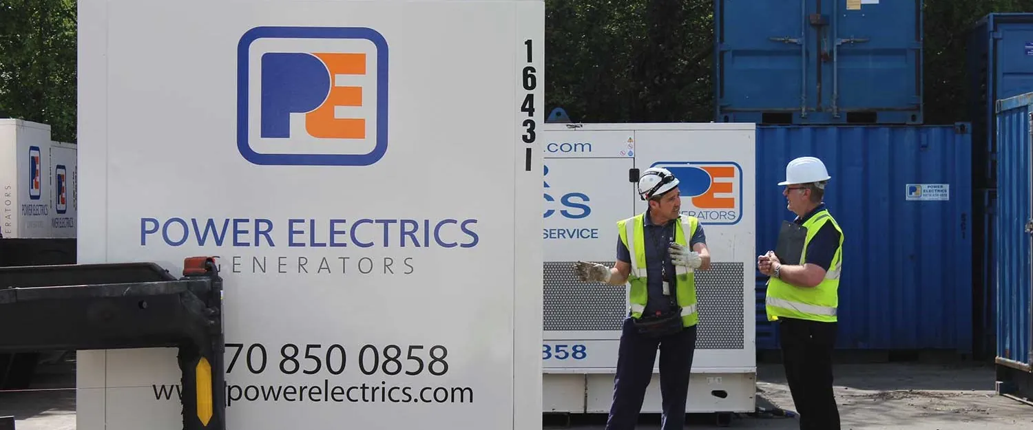 Power Electrics engineers beside one of their generators