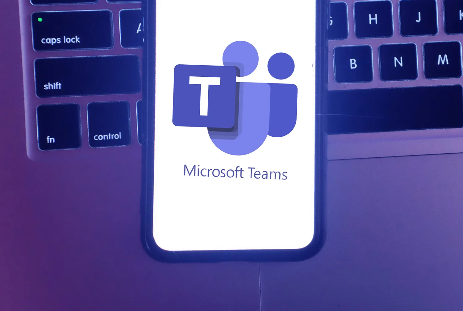 Smartphone showing the Microsoft Teams logo in front of a keyboard